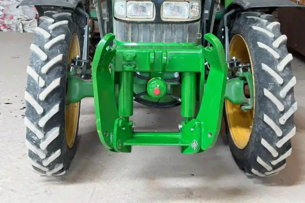 TM3000_PRO_03 Vista frontal de tractor John Deere equipado con elevador delantero hidráulico reforzado, diseñado para el acoplamiento de contrapesos y aperos frontales que mejoran la estabilidad, la tracción y el rendimiento en trabajos agrícolas.